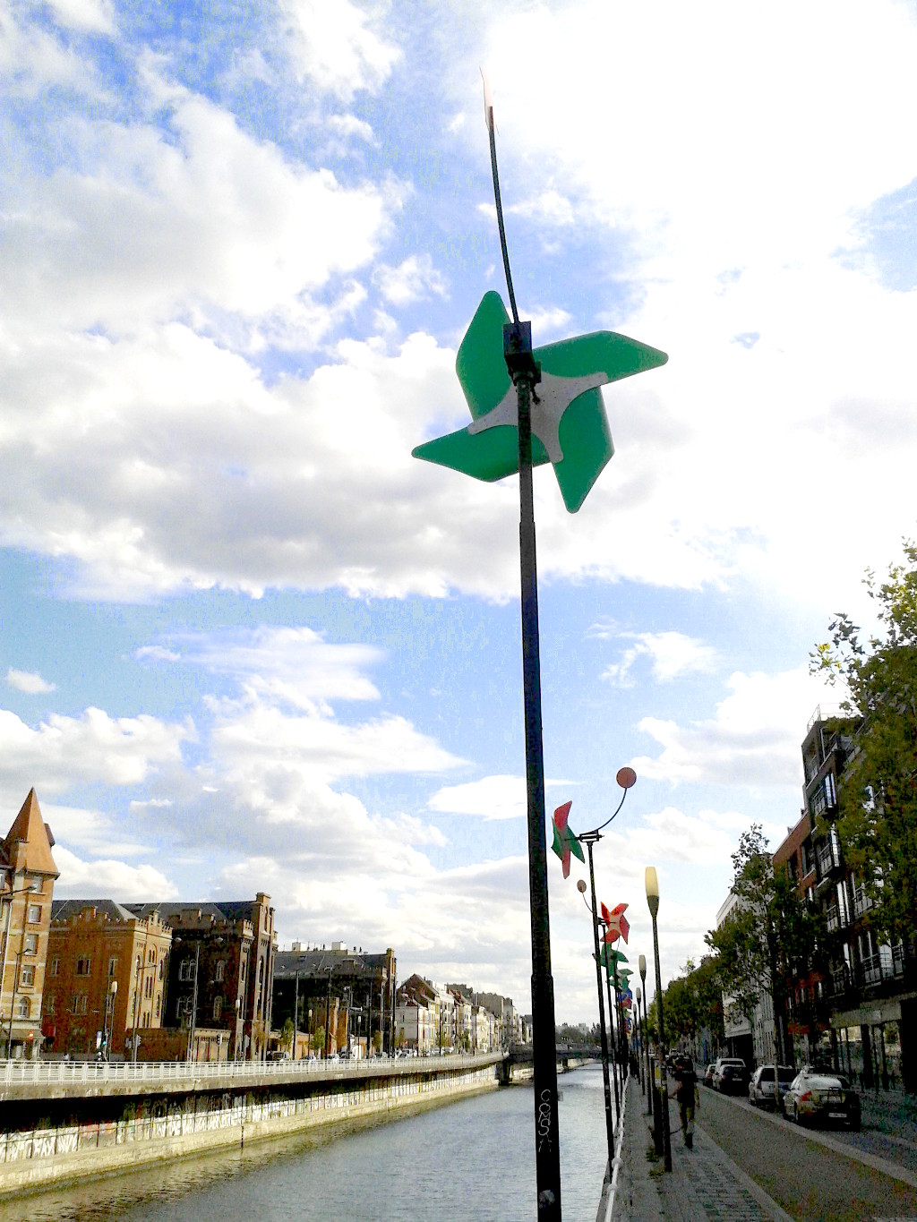 The Quai des Charbonnages besides the canal in Molenbeek, Belgium. Windmill sculptures adorn its banks.