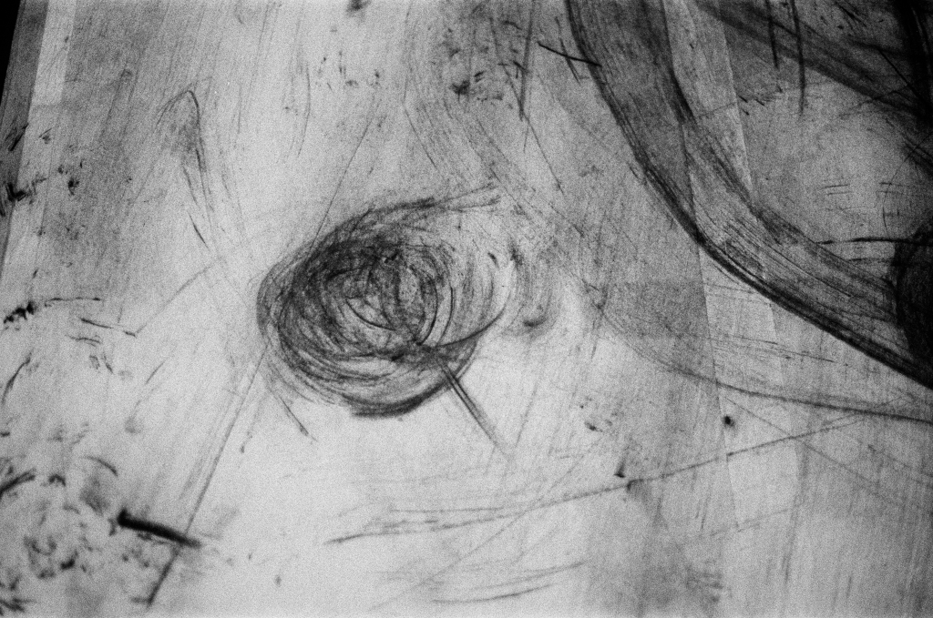 Residuals #1 image 011. Artists Andrew Wood & John Hazel. Charcoal on paper. Created 16 January 2024 at Old Fire Station dance studio, Oxford. UK. Photo: Andrew Wood. Black & whtie 35mm film photograph.