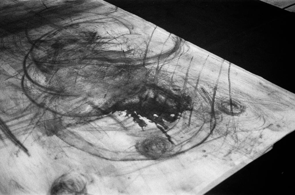 Residuals #1 image 012. Artists Andrew Wood & John Hazel. Charcoal on paper. Created 16 January 2024 at Old Fire Station dance studio, Oxford. UK. Photo: Andrew Wood. Black & whtie 35mm film photograph.