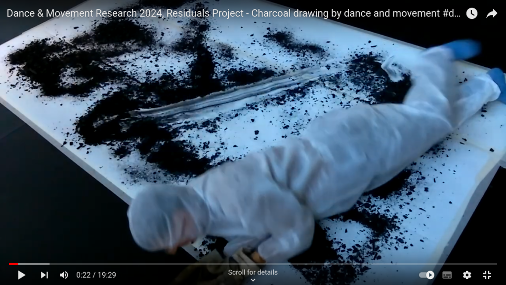 Andrew Wood sliding onto the surface of the paper, marking it with charcoal residuals in performance Residuals #1