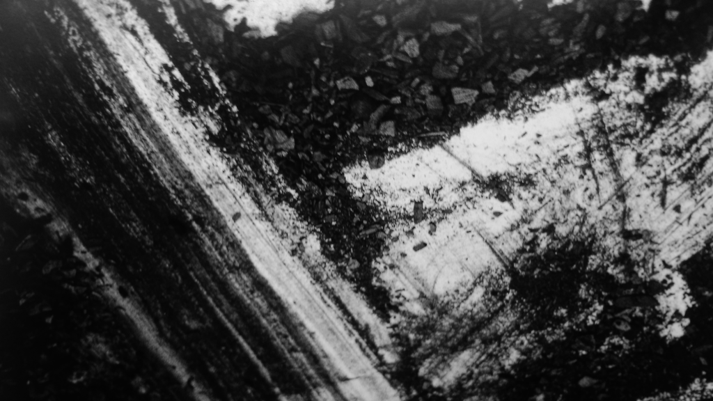 Detail of photograph showing surface of paper with charcoal residuals from Residuals performance #1 on Tue 15 January in dance studio at The Old Fire Station, Oxford, UK. Artists: John Hazel and Andrew Wood. Photo: Andrew Wood