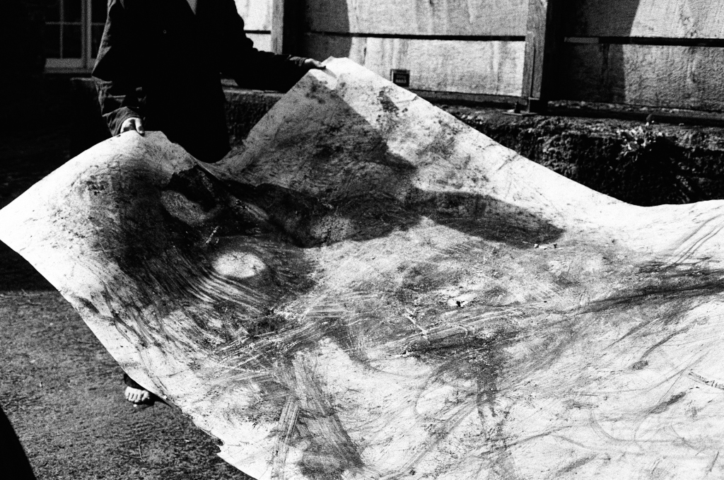 Drawing Residuals #2. John holds the finished drawing prior to being hung outside. Shippon Artists Studios, Dartington Estate, Devon, England. Photo: Andrew Wood