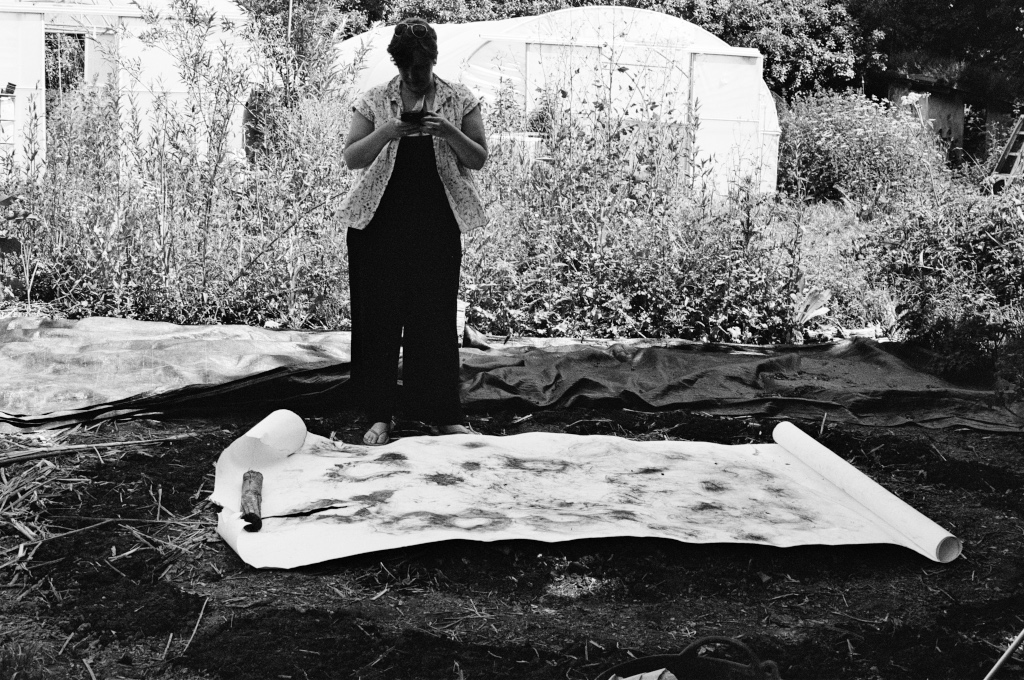 Residuals #4, Debra photographs the charcoal drawing from the planting performance, Community Garden at Schumacher College, Dartington on Sunday 2 June 2024.