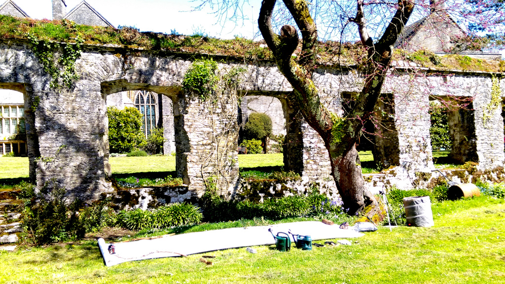 Residuals 3. The setting for the performance in Dartington Hall Gardens on Saturday 20 April 2024. This photograph prior to the performance, shows the drawing paper - measuring about 4m by 1.5m - set on the grass with tools and watering cans beside it.